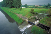 Ein offener Abwasserkanal mündet in einen Fluss